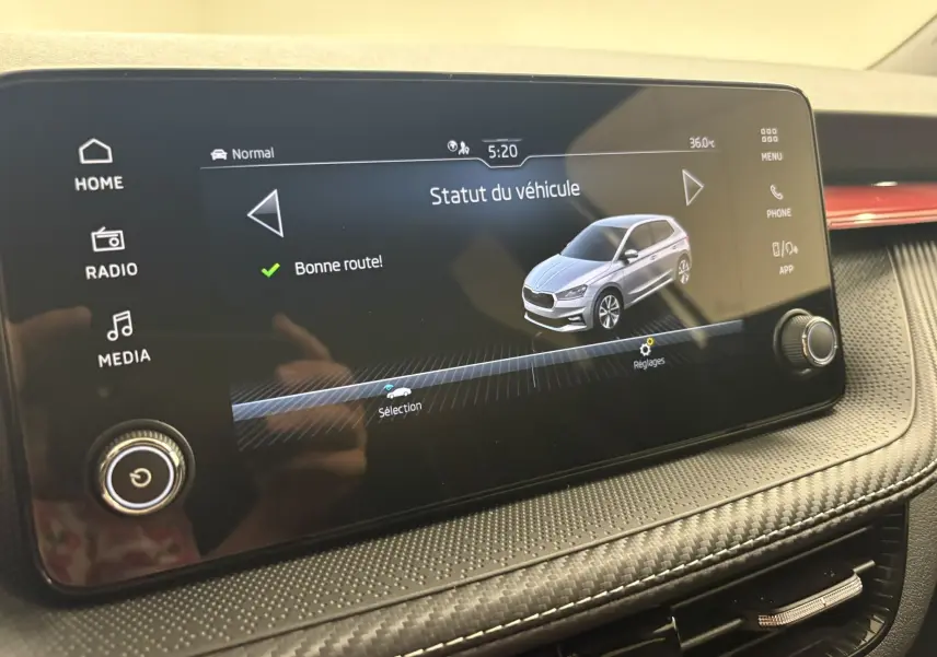 Écran tactile intérieur montrant le statut du véhicule Skoda Fabia gris argent en vue 3/4 avant, avec interface claire.