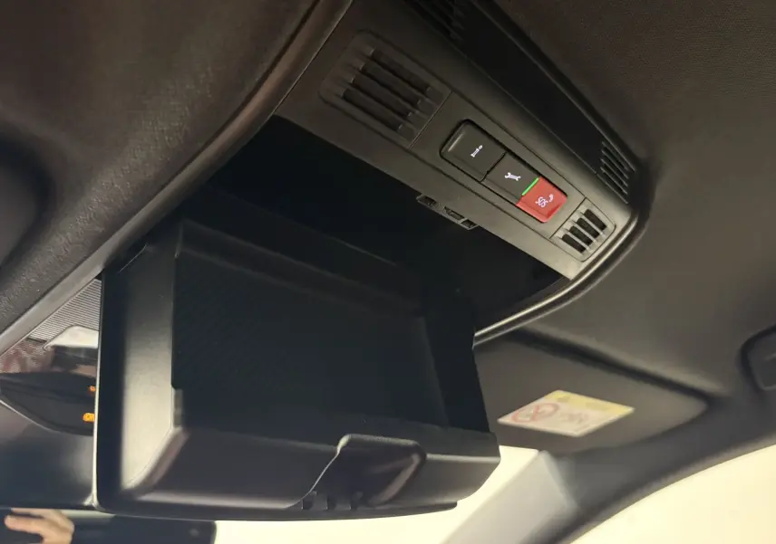 Vue intérieure en plongée du rangement plafond noir avec commandes d'assistance sur une Skoda Fabia 2025 gris argent toit noir.