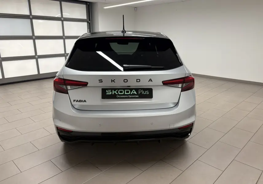 Vue arrière d'une Skoda Fabia 2025 gris argent avec toit noir, feux arrière LED et logo SKODA bien visible.