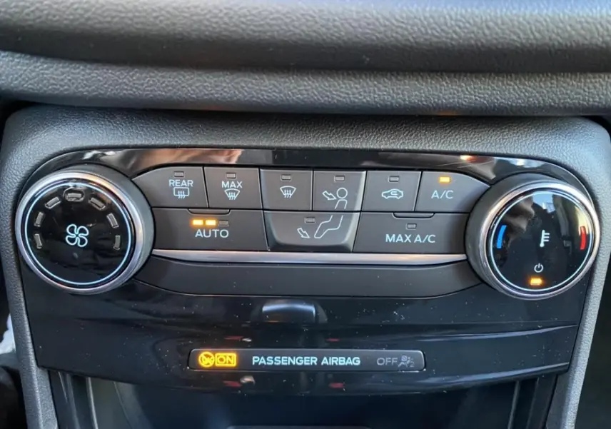 Gros plan sur la console de climatisation automatique du Ford Puma 2021 avec voyants et réglages lumineux allumés.