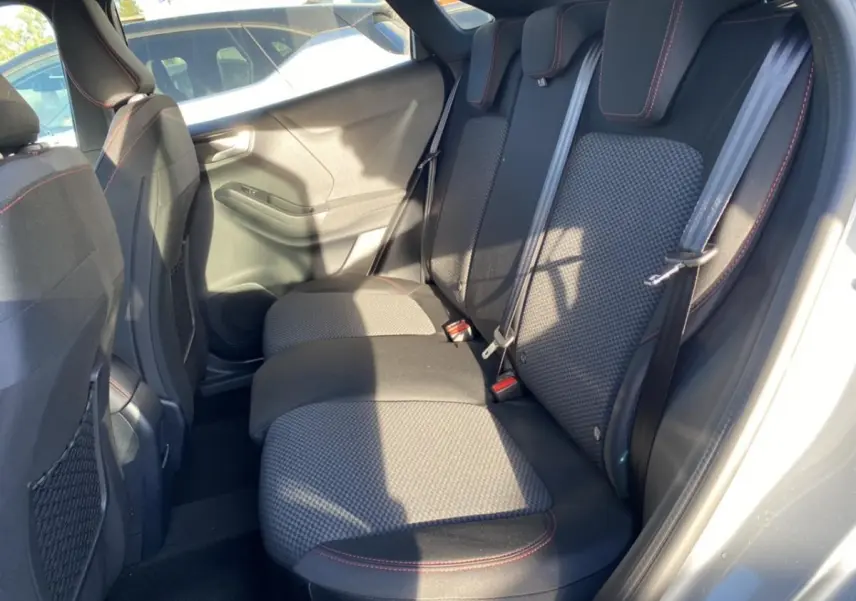 Banquette arrière en tissu gris avec surpiqûres rouges du Ford Puma gris, vue depuis la porte arrière droite ouverte.
