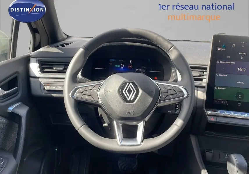 Vue centrée sur le volant et tableau de bord numérique du Renault Captur E-Tech hybride 2025, intérieur noir moderne.