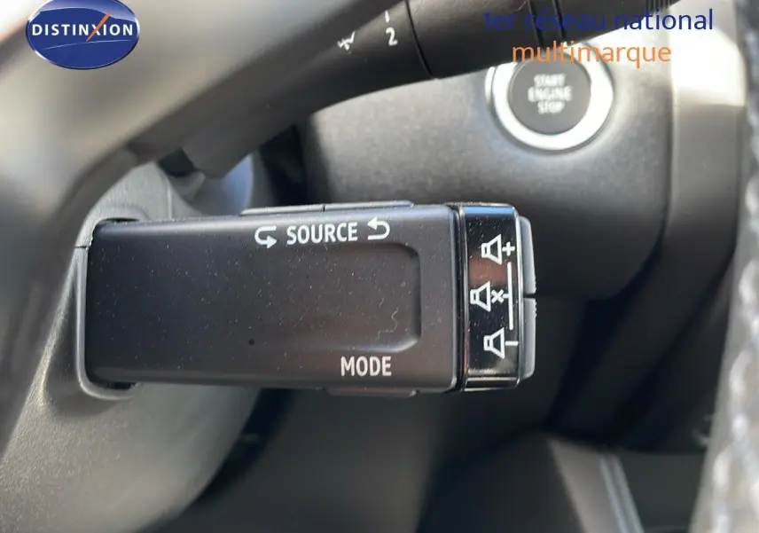 Gros plan sur la commande au volant du Renault Captur E-Tech hybride 2025, avec bouton source et mode visibles.