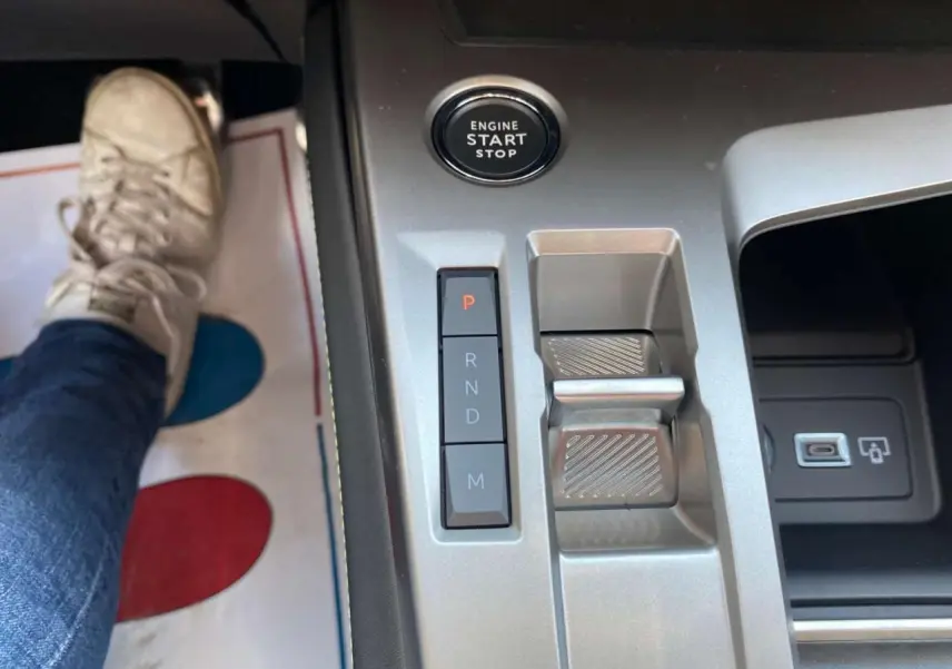 Gros plan sur la console centrale de la Peugeot 308 GT 2025 gris selenium, avec bouton start/stop et commandes de boîte auto.