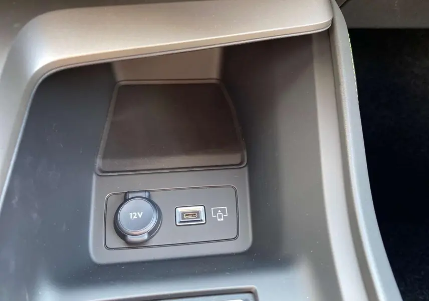 Prise 12V et port USB-C intégrés dans la console centrale d'une Peugeot 308 GT gris selenium 2025.