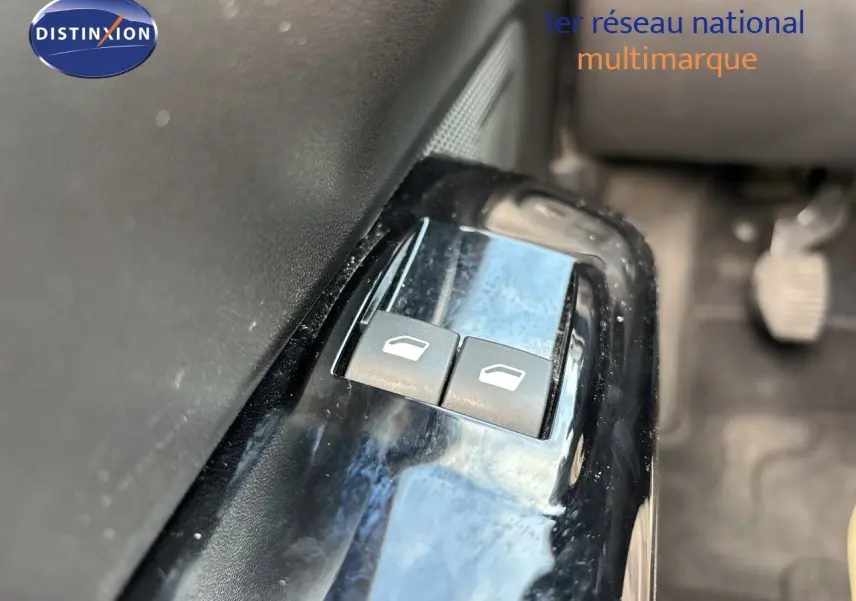 Gros plan sur les boutons de commande des vitres électriques côté conducteur d'une Citroën C3 blanche banquise de 2022.