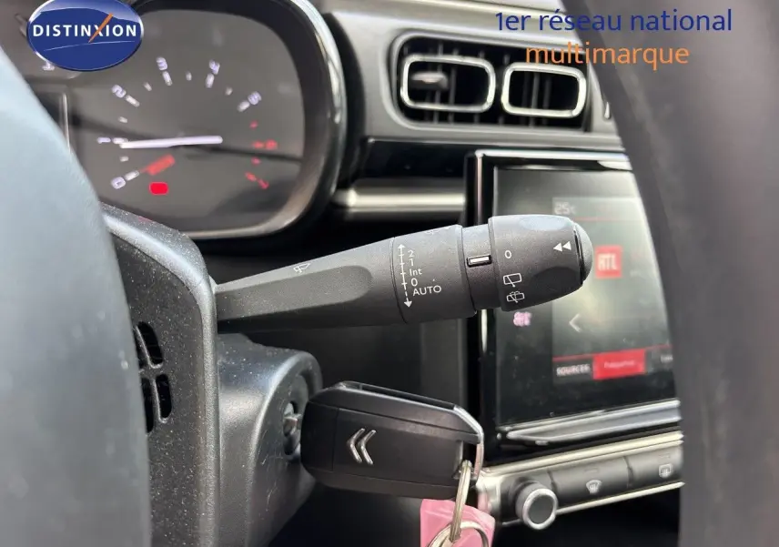 Gros plan sur la commande d’essuie-glace et le tableau de bord de la Citroën C3 blanche banquise, version 2022.