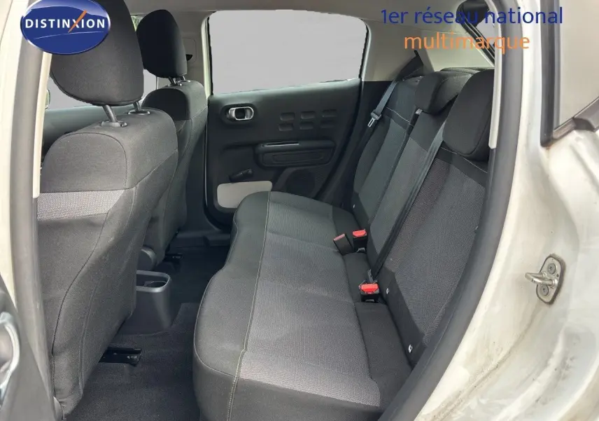 Vue intérieure arrière côté droit de la Citroën C3 blanc banquise, montrant la banquette arrière en tissu gris.