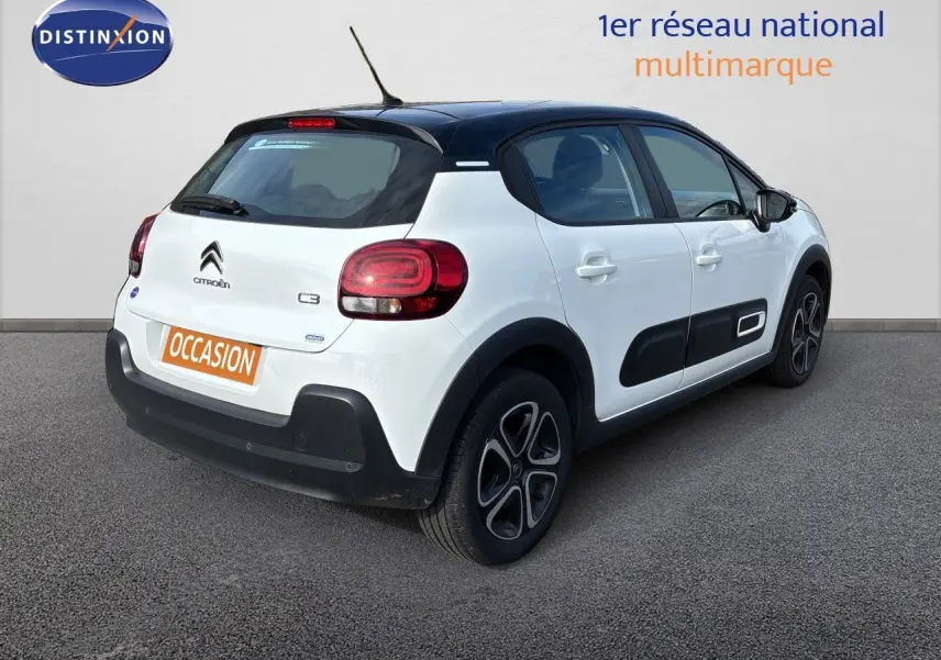 Vue 3/4 arrière droite d'une Citroën C3 blanche banquise avec toit noir et protections latérales noires.