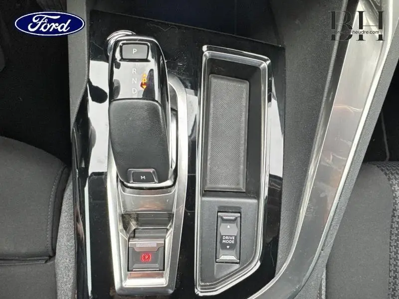 Gros plan sur la console centrale noire brillante avec levier de vitesse et bouton Drive Mode du Peugeot 5008 gris Platinium.
