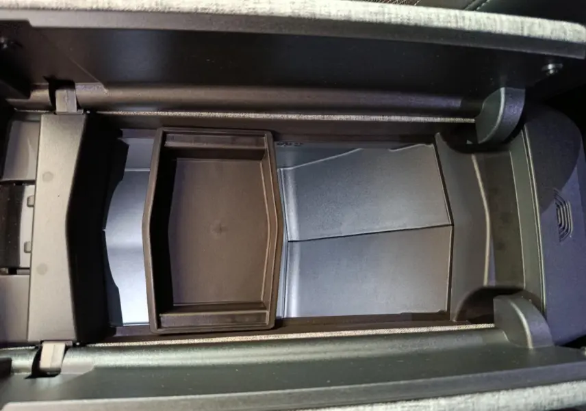 Vue plongeante sur le rangement central ouvert du Peugeot 3008 noir, montrant un compartiment modulable intérieur.