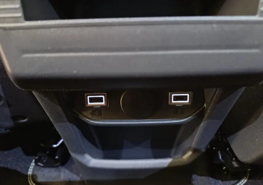 Vue rapprochée des ports USB arrière illuminés en blanc sur la console centrale noire du Peugeot 3008 2025.