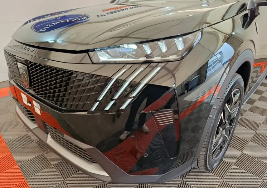Vue 3/4 avant droit du Peugeot 3008 noir 2025, mettant en valeur sa calandre distinctive et ses phares LED à griffes.