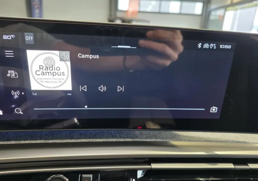 Écran tactile central du Peugeot 3008 gris titanium 2026 affichant une radio FM avec interface moderne.