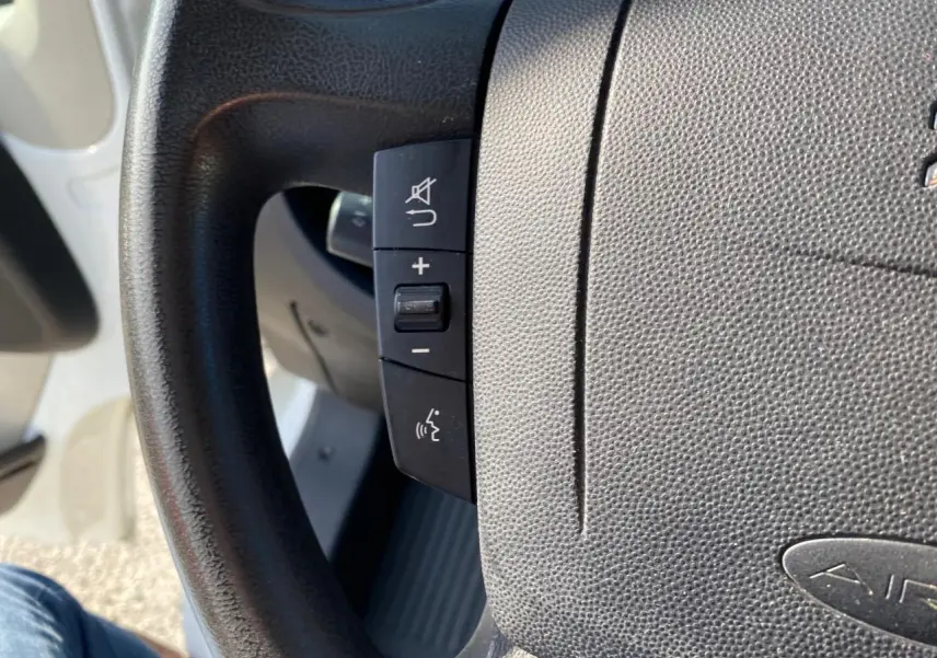 Gros plan sur le volant noir du Citroën Jumper blanc, montrant les commandes audio et téléphone intégrées.