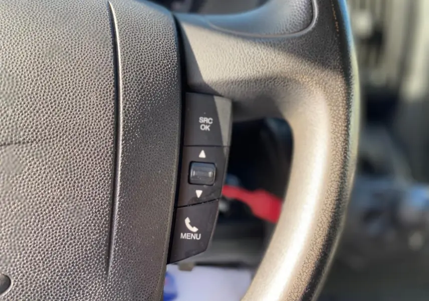 Gros plan sur les commandes du volant du Citroën Jumper blanc 2013, version Confort avec attelage.