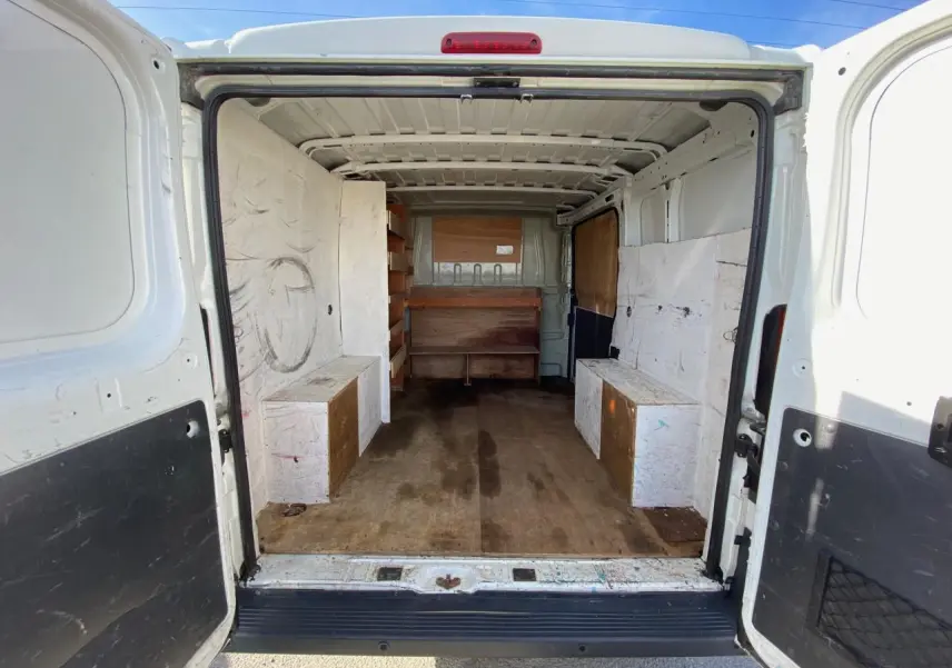 Vue arrière intérieure du Citroën Jumper blanc 2013, fourgon aménagé avec rangements en bois sur les côtés.