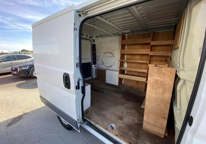 Vue latérale droite du Citroën Jumper blanc 2013 avec porte coulissante ouverte montrant l'intérieur aménagé en fourgon utilitaire.