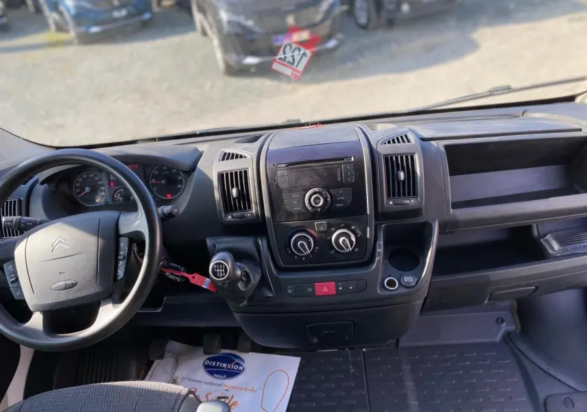 Vue intérieure du tableau de bord du Citroën Jumper blanc 2013, avec volant à gauche et levier de vitesses manuel.