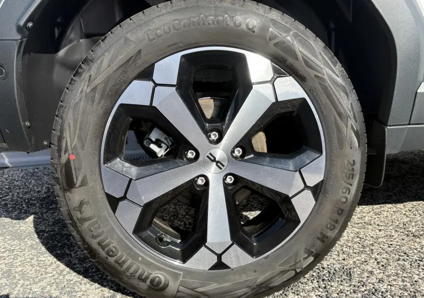 Gros plan sur la roue arrière droite d'un Dacia Duster blanc métallisé 2024, avec jante alliage et pneu Continental.