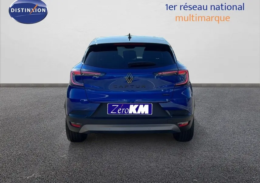 Vue arrière d'un Renault Captur bleu Iron Metal avec toit noir, version hybride E-Tech 2025, sur fond neutre.