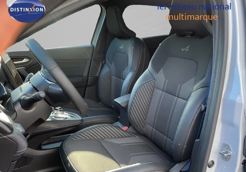 Vue intérieure côté conducteur du Renault Captur E-Tech gris rafale avec sièges Alpine en cuir noir et surpiqûres blanches.