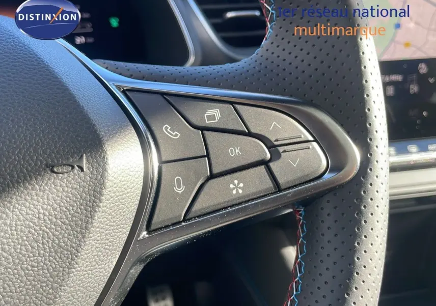 Gros plan sur les commandes au volant en cuir perforé avec surpiqûres tricolores du Renault Captur gris Rafale toit noir.