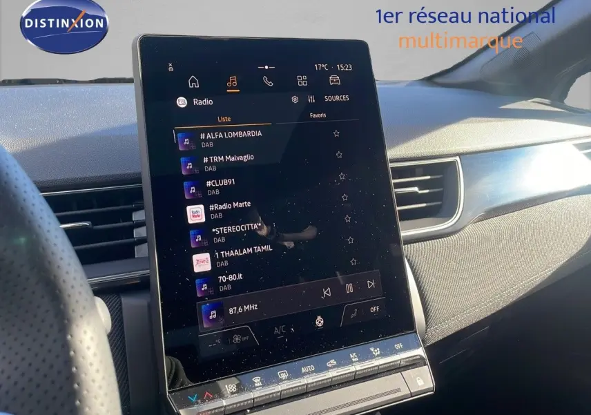 Écran tactile central allumé dans l'habitacle d'une Renault Captur gris rafale avec toit noir, vue côté conducteur.