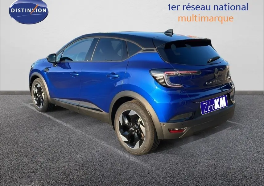 Renault Captur E-Tech hybride bleu Iron Metal avec toit noir, vue 3/4 arrière côté gauche sur parking.