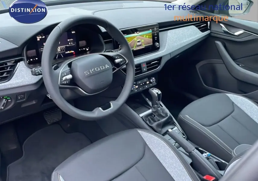 Vue intérieure côté conducteur du Skoda Kamiq gris graphite, montrant le volant, tableau de bord digital et sièges bi-matière.