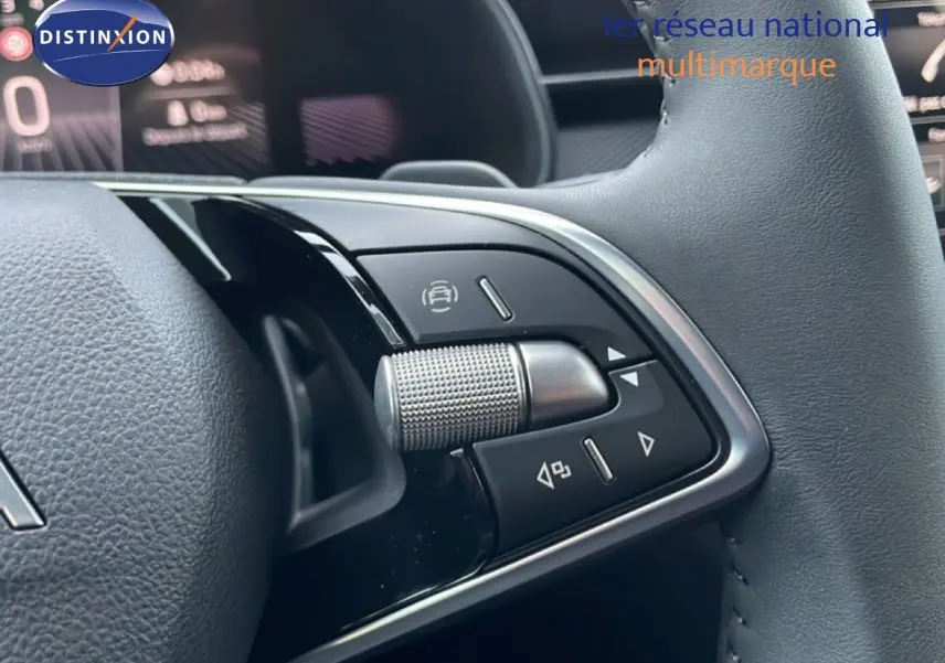 Gros plan sur les commandes au volant gris d’un Skoda Kamiq, avec tableau de bord numérique en arrière-plan.