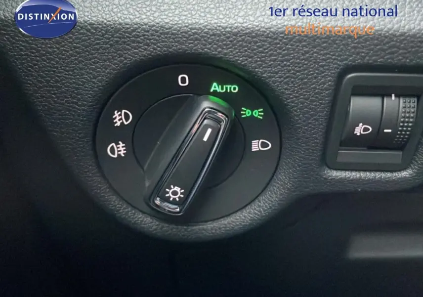 Gros plan sur la commande des phares et réglage d'intensité lumineuse dans l'habitacle du Skoda Kamiq gris graphite.