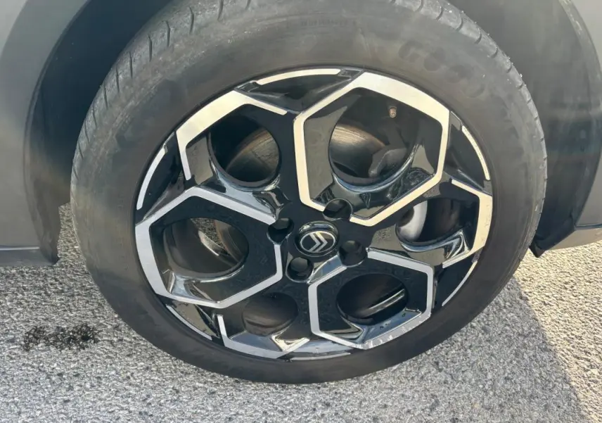 Gros plan sur la jante alliage 17 pouces noire et argentée du Citroën C3 Turbo 2025, avec logo central visible.