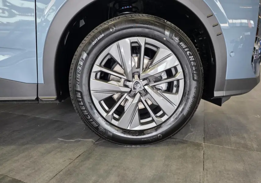 Gros plan sur la roue avant droite du Peugeot 3008 bleu avec jante alliage 18 pouces Basel et pneu Michelin.