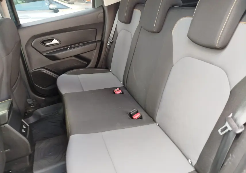 Vue intérieure côté droit des sièges arrière en tissu gris et noir du Dacia Duster 2024, version 1.5 Blue dCi Extreme.