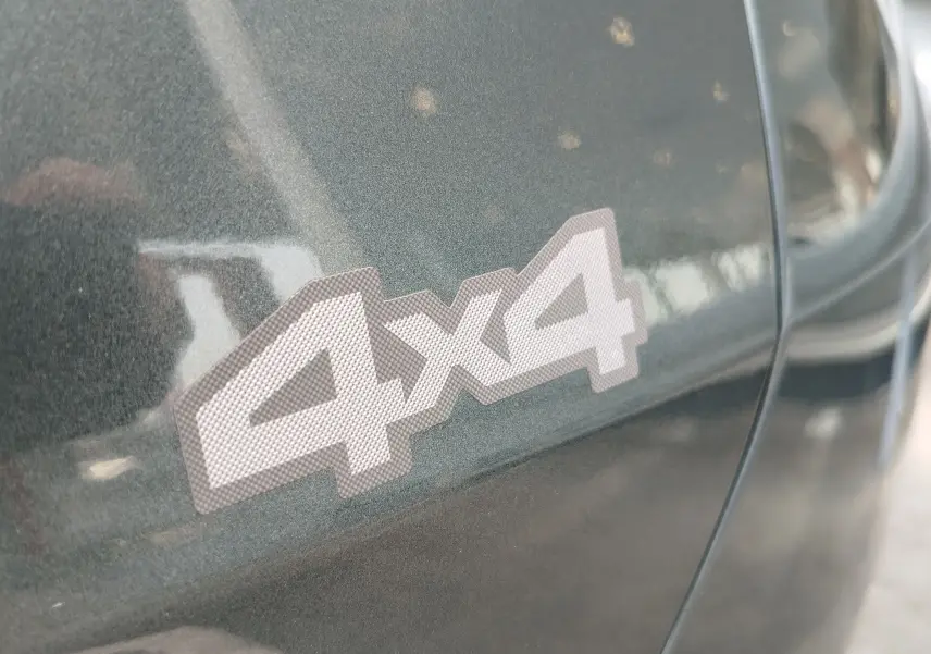 Gros plan sur l’autocollant 4x4 sur la portière d’un Dacia Duster Vert Cèdre métallisé 2024.