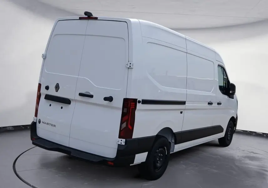 Vue 3/4 arrière droite d’un Renault Master blanc L2H2 avec portes arrière fermées et feux arrière verticaux rouges.