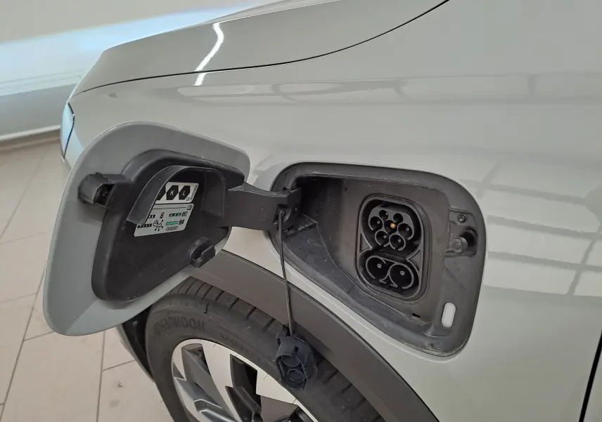 Prise de recharge ouverte côté gauche sur Skoda Kodiaq gris perle avec jante alliage 19 pouces visible.