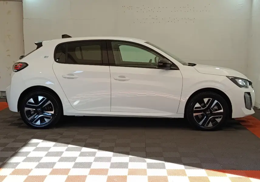 Peugeot 208 électrique blanc vue de profil côté gauche, avec jantes noires et détails modernes sur les phares.