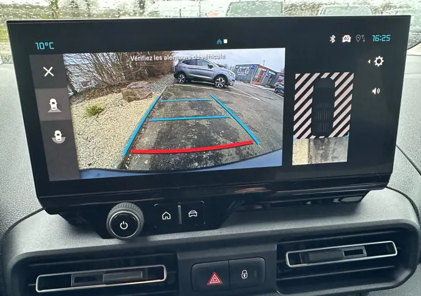 Écran central du Citroën Berlingo 2025 gris Artense montrant la caméra de recul avec vue arrière et lignes de guidage colorées.
