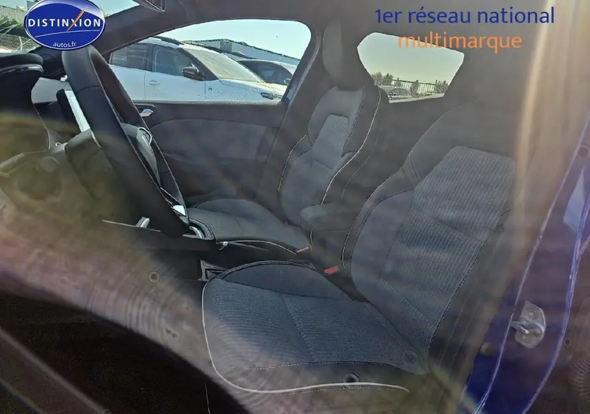 Vue latérale intérieure des sièges avant sport gris foncé de la Renault Clio V Bleu Iron avec porte ouverte côté droit.