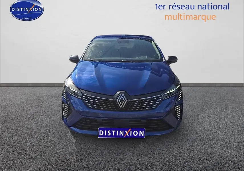 Vue avant d'une Renault Clio V 1.6 e-tech 145 techno bleu iron avec calandre chromée et feux LED allumés.