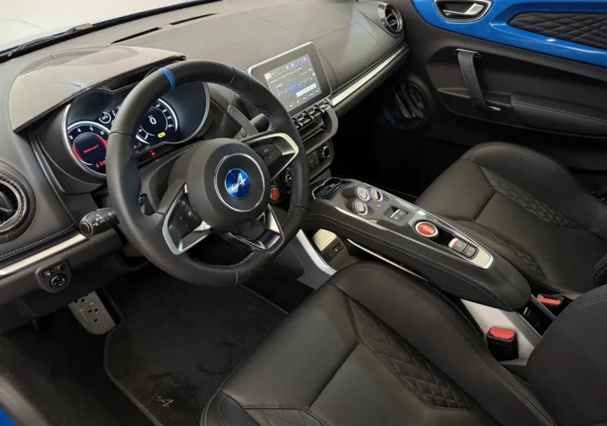 Intérieur de l'Alpine A110 Legende 2019, vue côté conducteur, cuir noir et panneau de porte bleu vif.