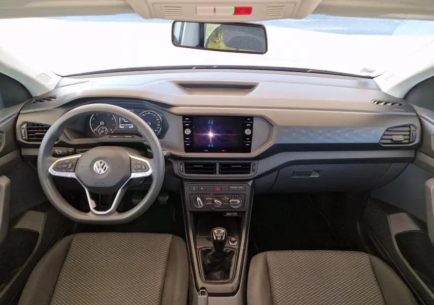 Vue intérieure frontale du Volkswagen T-Cross 2019, tableau de bord gris avec volant multifonction et boîte manuelle.