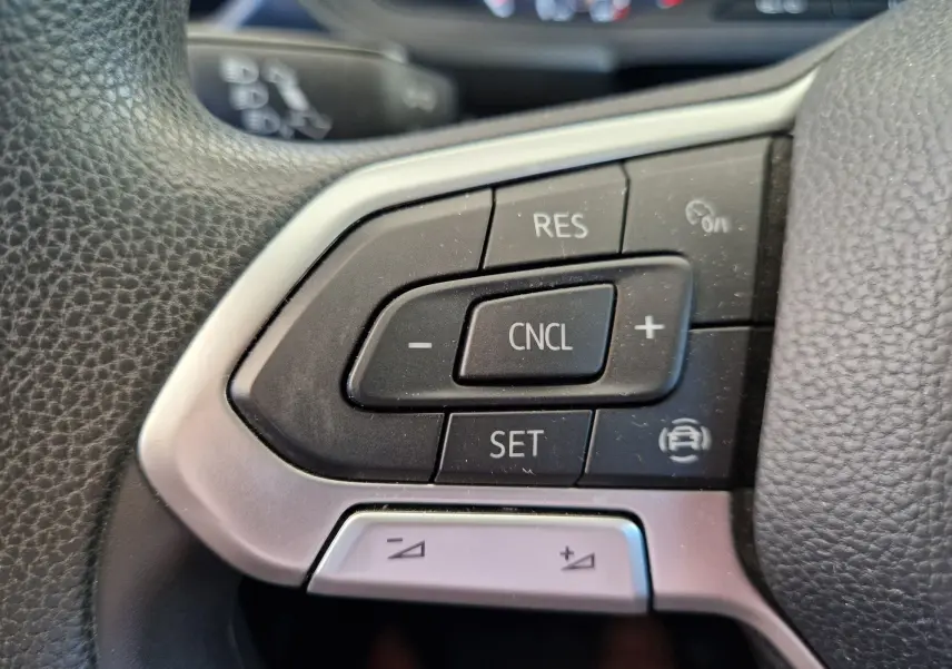 Gros plan sur les commandes du régulateur de vitesse adaptatif au volant du Volkswagen T-Cross argent métal 2019.