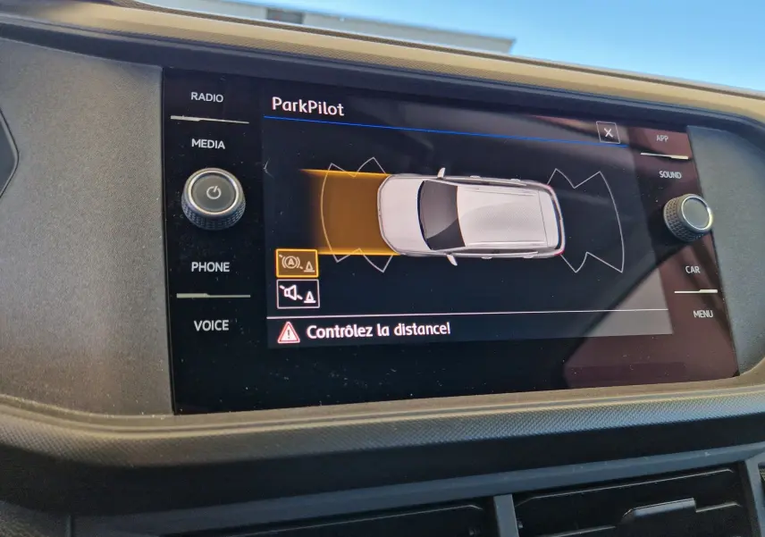 Écran central du Volkswagen T-Cross argent métal 2019 montrant l'alerte ParkPilot avec contrôle de distance actif.