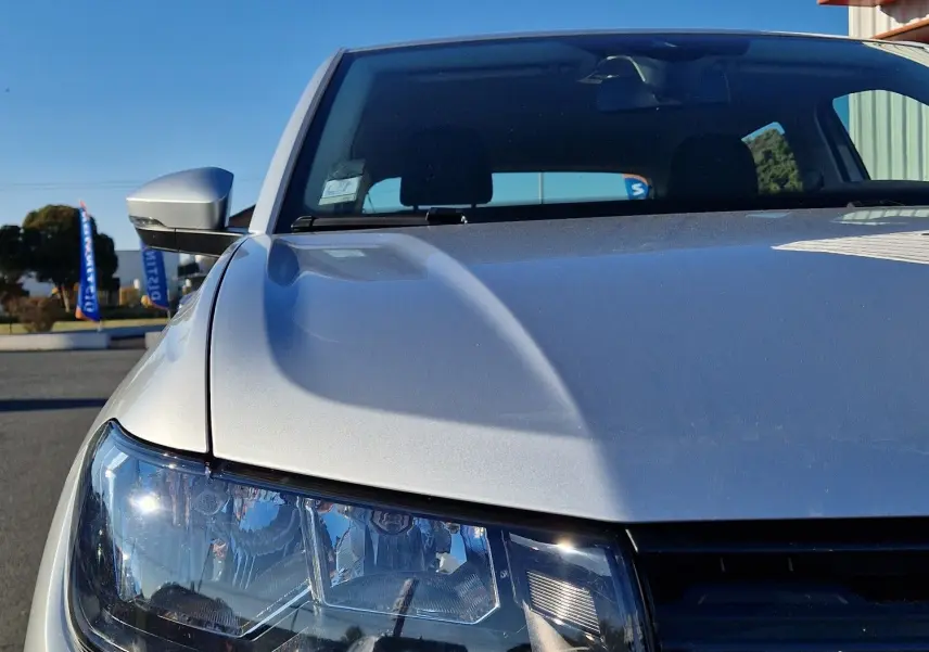 Vue avant rapprochée du Volkswagen T-Cross 2019 argent métal, mettant en valeur son phare et la calandre noire.