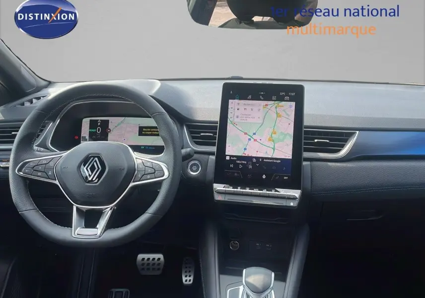 Vue intérieure du tableau de bord du Renault Captur E-Tech hybride 2025, avec volant multifonction et écran tactile central.