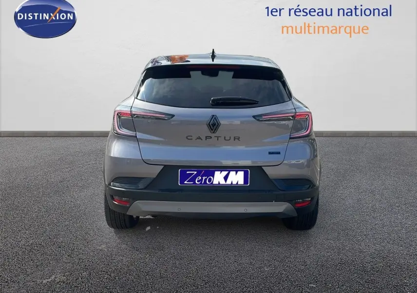 Vue arrière d'un Renault Captur E-Tech hybride gris cassiopée avec toit noir, affichant ses feux LED et logo distinctif.