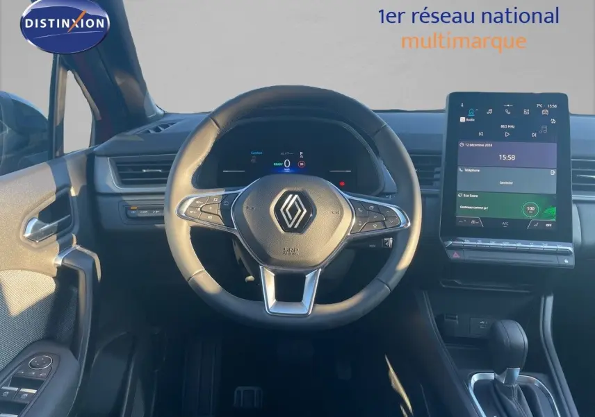 Vue intérieure centrée sur le volant et l’écran tactile du Renault Captur E-Tech rouge passion avec toit noir.